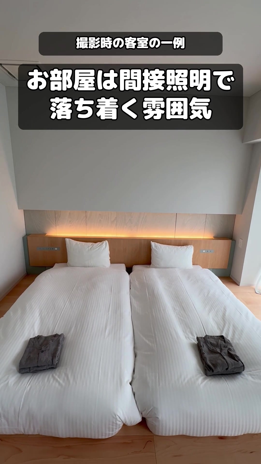 ITOMACHI HOTEL 0の間接照明とベッド2台が見える客室