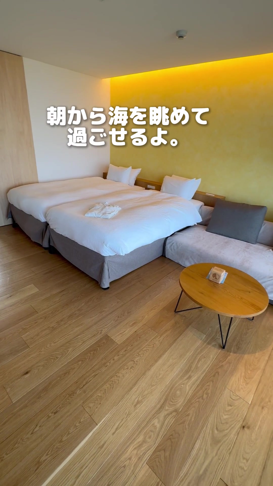 そらすなのベッド2台とソファ、丸テーブルのある客室