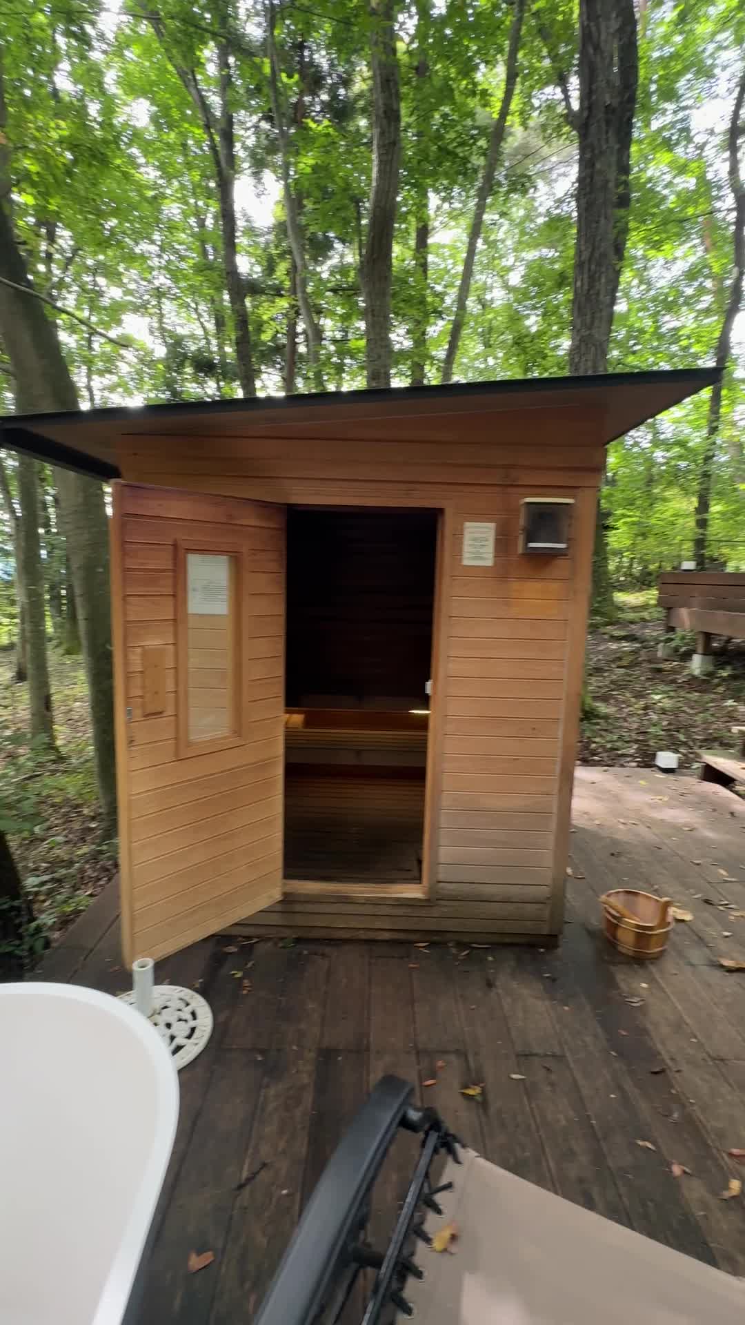 ツキミチルの屋外の木製サウナ小屋と内部のベンチ